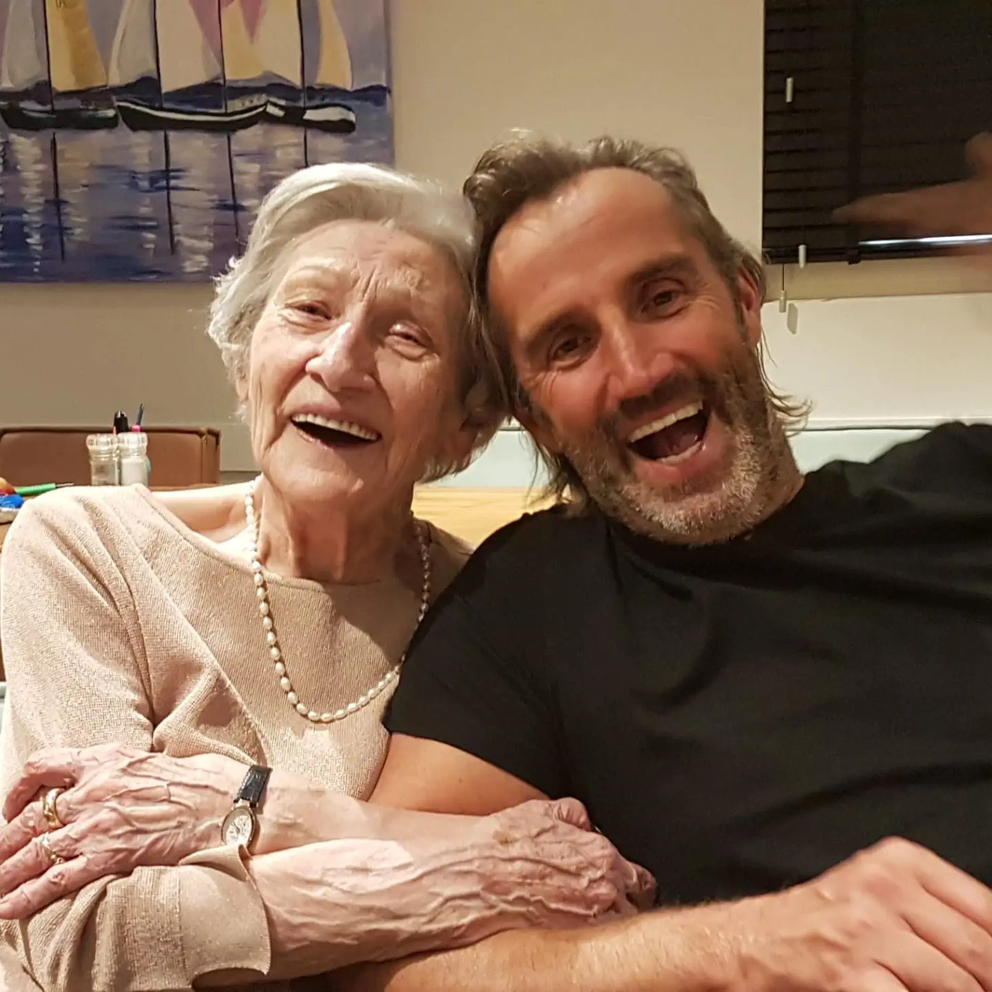 Een ouder dame lachend met een jongere man